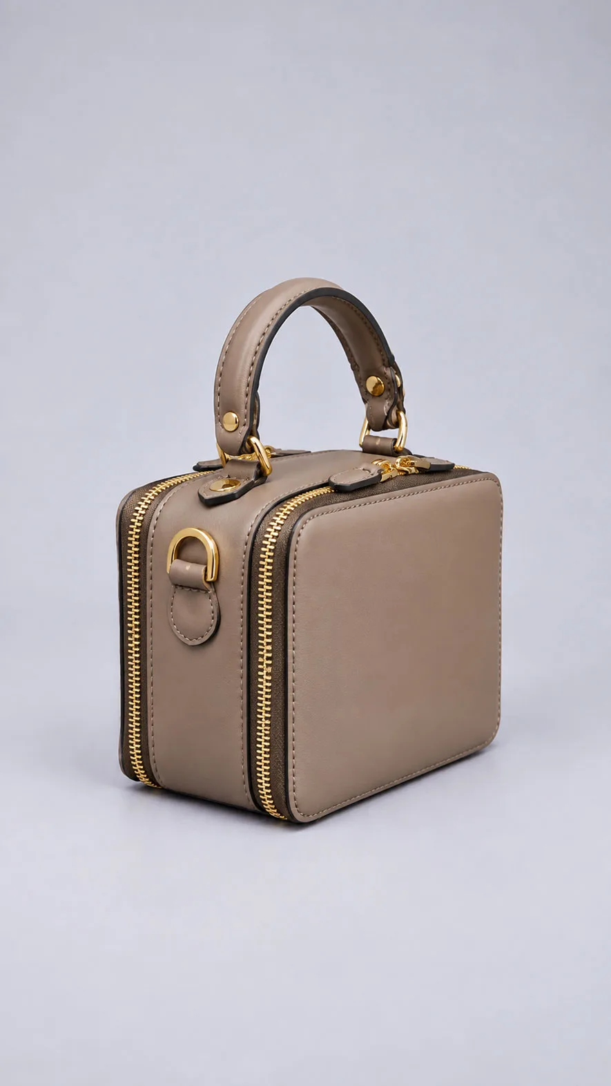 HB1008 taupe mini leather handbag showing gold zippers and shoulder strap ring, angled view